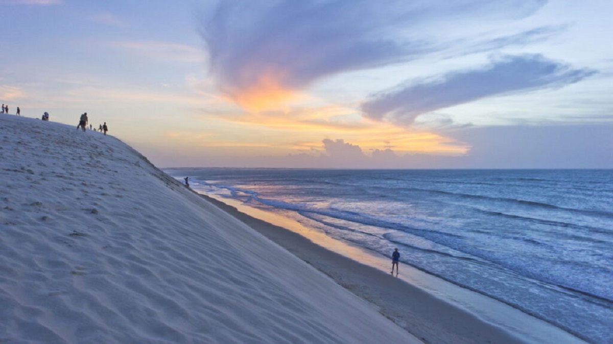 Vista aérea da Lagoa do Paraíso em Jericoacoara com dunas de areia branca ao redor e águas azul-turquesa